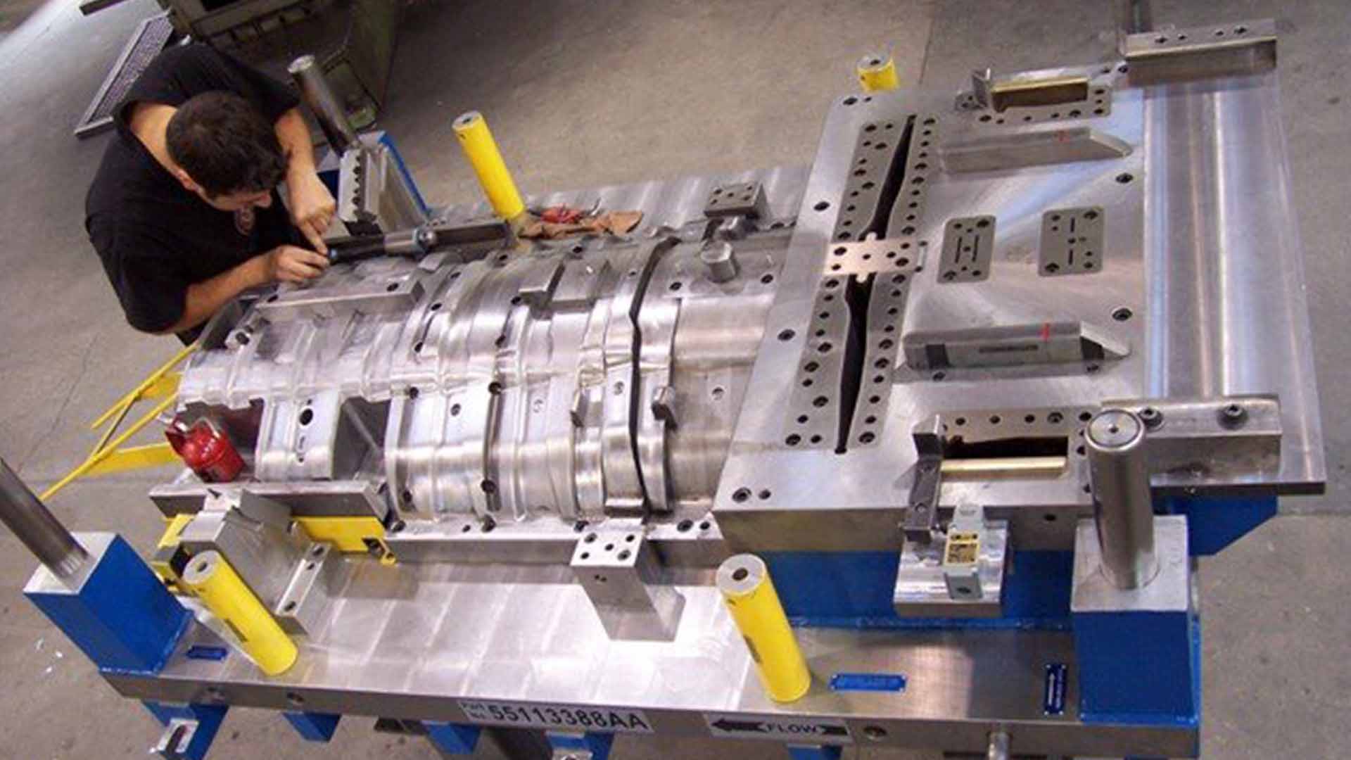 Técnico ajustando una matriz de estampado de gran formato en el taller